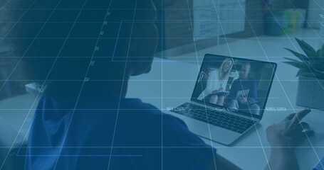 Watching woman in blue top leaning toward laptop at desk, with presenters wearing blazer jacket