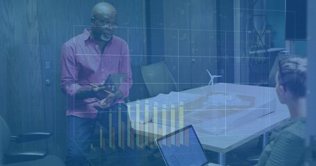 Presenting man in pink top using tablet-pen in conference room with wind turbine and projected data