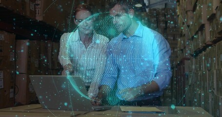 Two coworkers in business shirts reviewing laptop and papers in archive with data globe