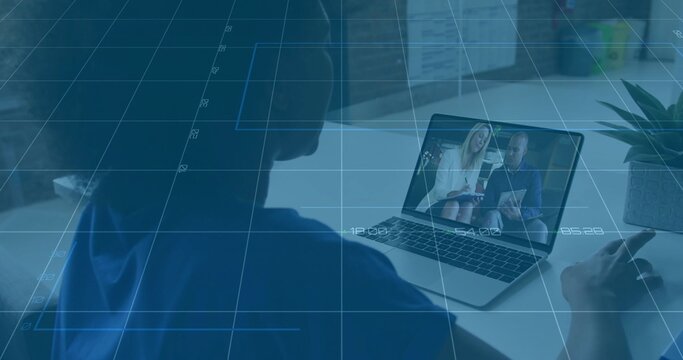 Watching woman in blue top leaning toward laptop at desk, with presenters wearing blazer jacket