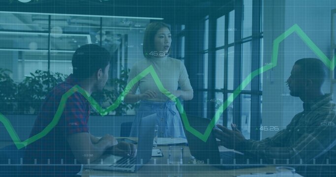 Leading Asian woman with tied jacket directing meeting in office, laptops and green chart overlay - Powered by Adobe