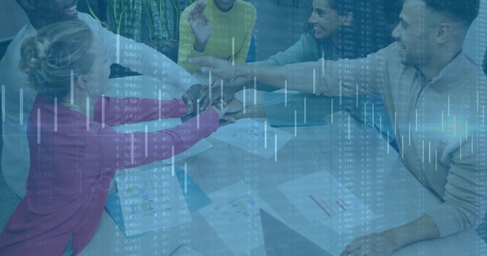 Leaning 5 colleagues stacking hands at glass table, in business attire with printed charts overlay