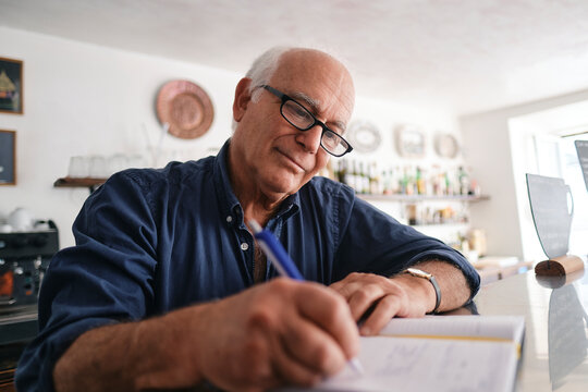 Smiling cafe owner writing in diary