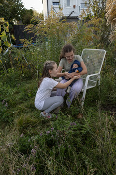 Children are relaxing in the garden behind the house. Family weekend