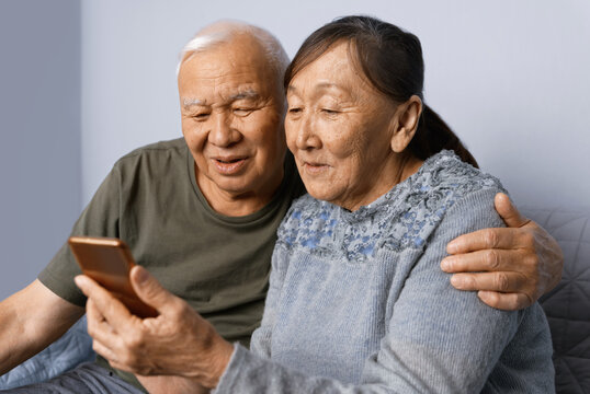 Senior couple at home using smartphone
