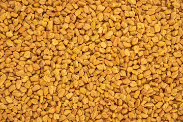 Pile of fenugreek seeds for background. Top view