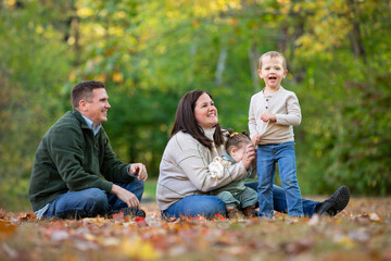 A young boy smiles while his parents try to get his attention