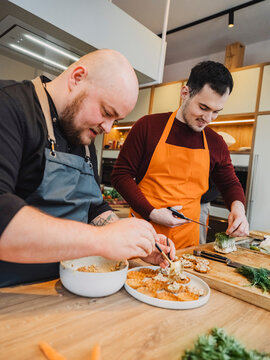 Friends preparing pastry together in a cooking class kitchen