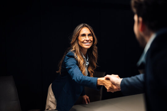 Business professionals shaking hands in a modern meeting room