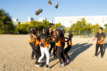 Baseball team celebrating victory throwing gloves in air