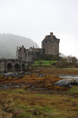 Eilean Donan Castle in Scotland, a historic medieval fortress perched on island, connected by a stone bridge and surrounded by scenic loch and hills.