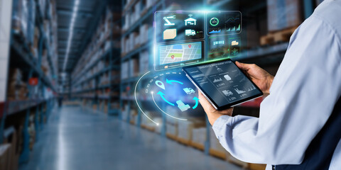 Business Logistics warehouse management system technology concept.Man hands using tablet on blurred warehouse as background