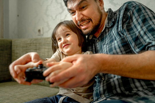 Father and son playing video games at home