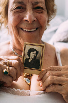 Senior woman holding old picture at home