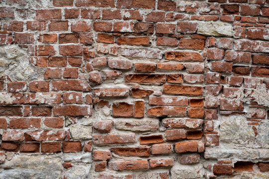 old brick wall background, uneven, cracked and rough surface