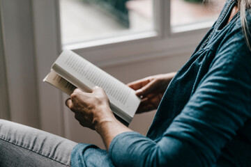 Woman reading book, partial view