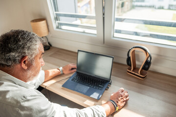 Senior man telecommuting and working from home office