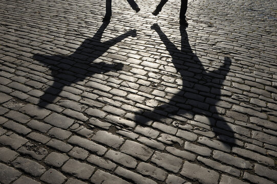 Germany, Bavaria, Rothenburg ob der Tauber, Shadow of people on cobblestone