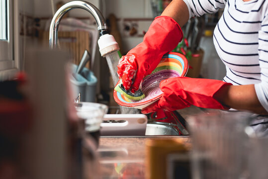 Mature woman scrubbing dish in kitchen