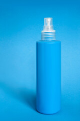 Spraying bottle on blue background