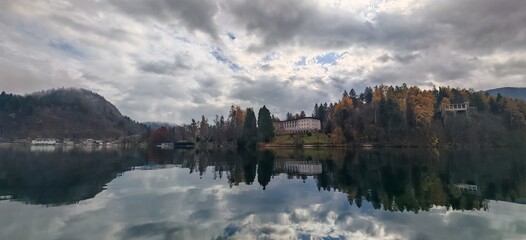 Fototapeta premium Bled - Slovenia - Mountain lake with reflective water and dramatic cloudy sky