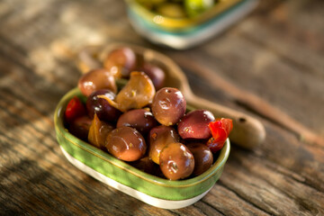 Olive, olives homemade marinated colorful olives with herbs and spices on rustic table, close up. Healthy Mediterranean vegan food, macro shot  