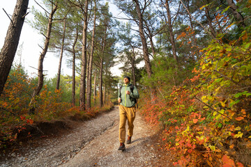 Happy runner on the forest path in autumn