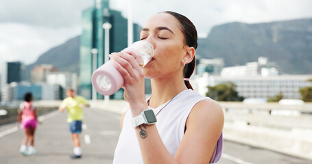 Woman, fitness and drinking with water bottle in city for workout break, rest or recovery. Active,...