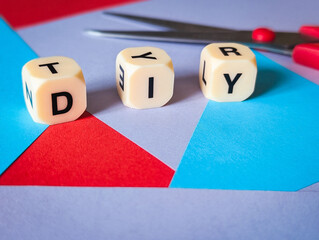 diy do it yourself concept on geometric paper background with craft scissors