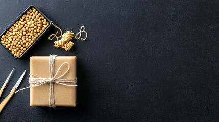 A gift box tied with twine sits next to a black container filled with soybeans and a small pile of fusilli pasta.