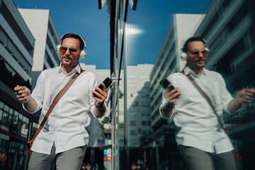 Man enjoying music walking city street reflection