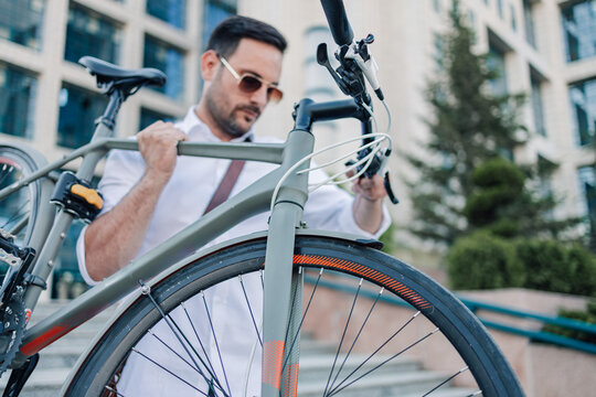Businessman carrying bicycle up urban stairs