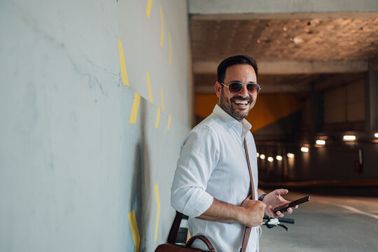 Happy man communicating on phone in a parking garage - Powered by Adobe