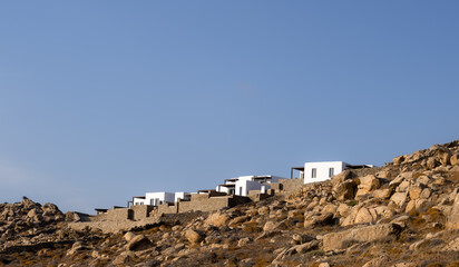minimalist background with modern luxury white villas on the top of the sandy deserted hill on clear blue sky backdrop