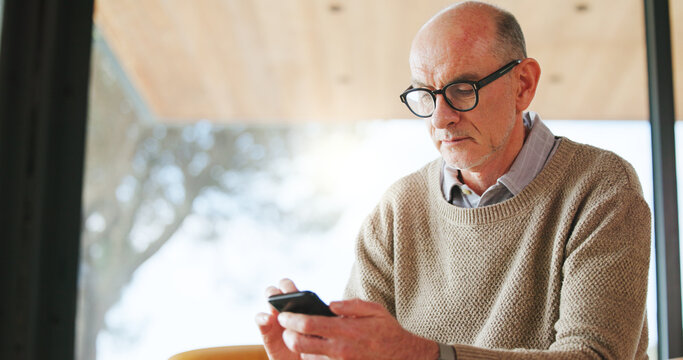 Reading, glasses and old man with smartphone, home and browsing article on social media and website. Scroll, news and senior person with mobile app for story, vision and eyewear for eyesight in house - Powered by Adobe
