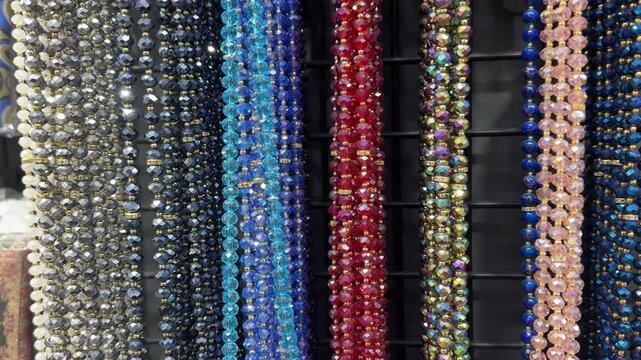 Rows of sparkling multicolored beads hang in vertical strands on display