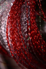  Detailed closeup of shimmering red metallic wire coils intertwined in an intricate pattern. The vibrant strands reflect light, creating a dynamic and dazzling visual effect