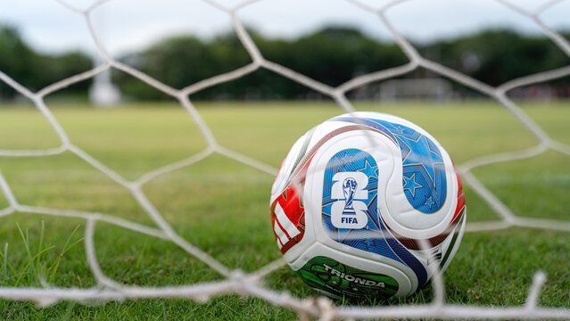 Bangkok, Thailand - 18 November 2025: Adidas "Trionda" the official match ball for Fifa World Cup 2026 that co-host in America. The ball is placed on grass pitch with football stadium component.