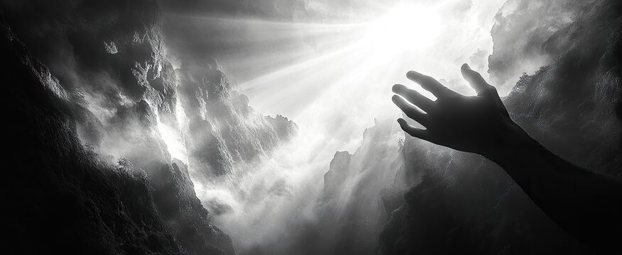 Monochromatic image of a hand reaching towards a bright light amidst dark, stormy clouds; evokes themes of hope, faith, or struggle against adversity