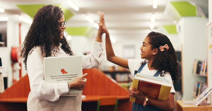 Happy woman, teacher or student with high five in library for education, learning or success. Female person, educator or smile with kid, girl or child for literature, reading or well done in bookshop - Powered by Adobe