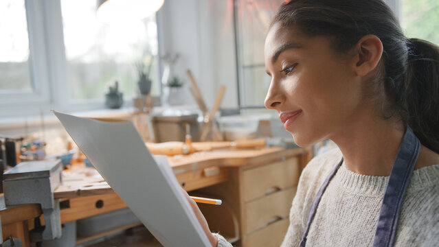 Female Jeweller Sketching Out Design For Ring In Studio - Powered by Adobe