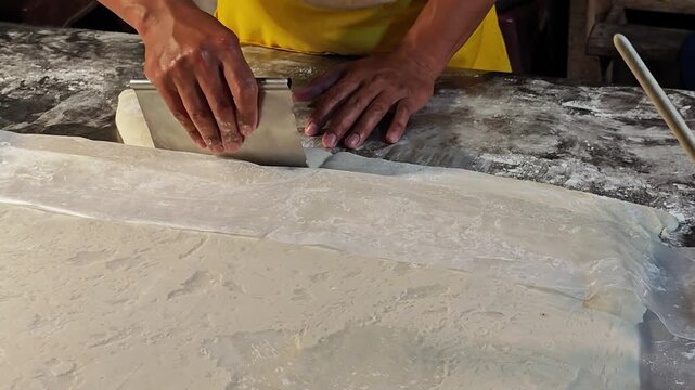Cutting raw dough for Thai and Chinese style fried dough stick.
