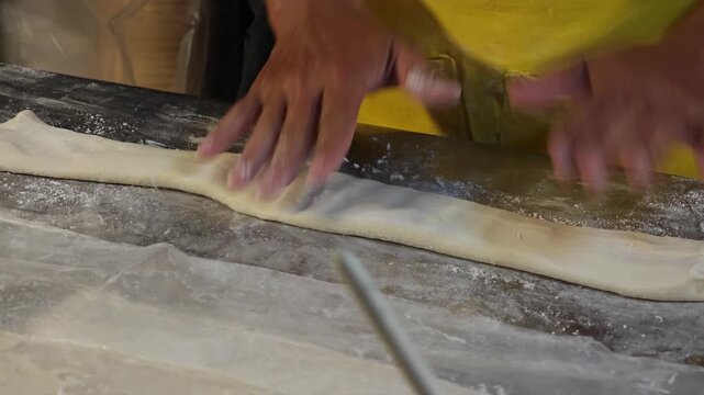 Making dough stick with hand and roller.