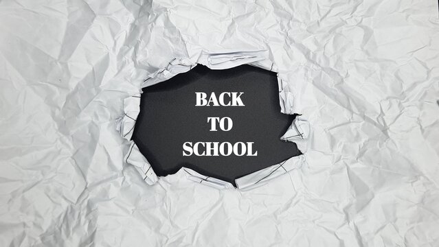 Conceptual image of 'Back to School' revealed by a tear in wrinkled white paper. Perfect for headers