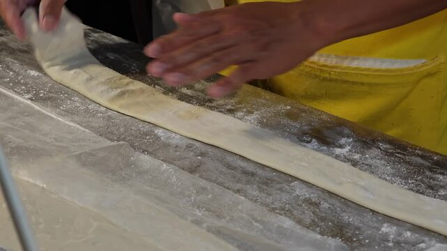 Making dough stick with hand and roller.