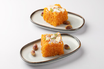 Two slices of Orange halwa served in ceramic plates, Famous delicious Indian dessert