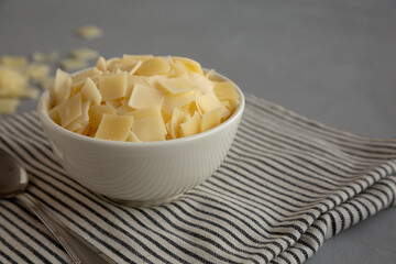 Hard Shaved Parmesan Cheese in a Bowl, side view. Close-up.