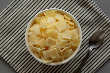 Hard Shaved Parmesan Cheese in a Bowl, top view. Flat lay, overhead, from above.