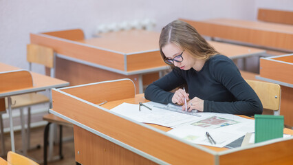 Caucasian young woman making drawings. Student of architecture university.