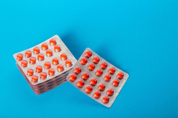 Stacks of blisters with red vitamin tablets. Top view. Multivitamin complex for health. Copy space for text